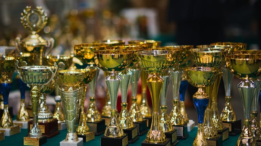 pexels-photo-29707905 Array of golden trophies on a table, reflecting victory and achievement.